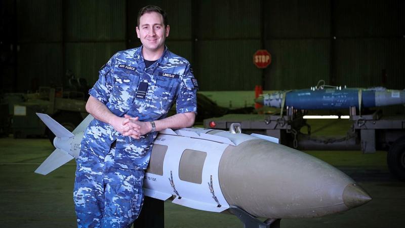 Defence Explosive Ordnance Training School instructor Flight Lieutenant Ben Lindsay with a teaching aid, a 2000-pound joint direct attack munition.