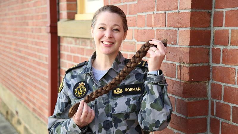 Leading Seaman Musician Miriam Norman from the Royal Australian Navy Band Tasmania shows of the braid of hair she has donated to charity.