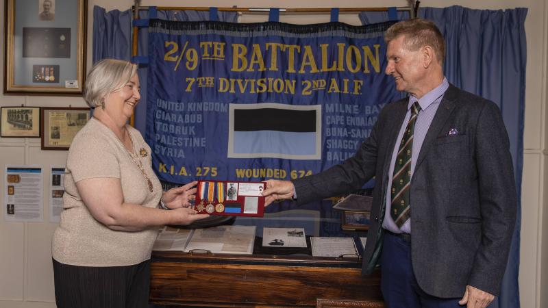 Len Kelly returns the medals of World war I veteran Lieutenant Norman Weynand to his family member Lynne Bennett at the 9th Battalion Museum at Gallipoli Barracks Brisbane.