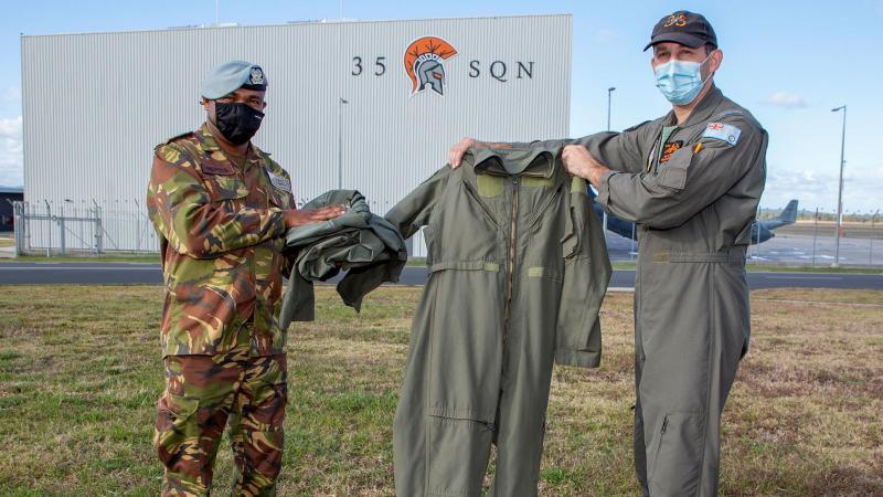 Captain Randall Hepota of the Papua New Guinea Defence Force is presented with flying clothing during his visit to No. 35 Squadron at RAAF Base Amberley by Squadron Leader Robert Crawford. Photo: Sergeant Peter Borys