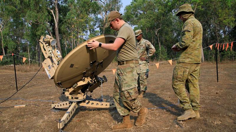 US Air Force (USAF) Tech Sergeant Roy Rogan, left, UASAF Senior Airman John Kelsey and Royal Australian Air Force aviator Leading Aircraftman Cayden Kingsford rotate a satellite dish at RAAF Base Scherger. Photo: Corporal Brett Sherriff