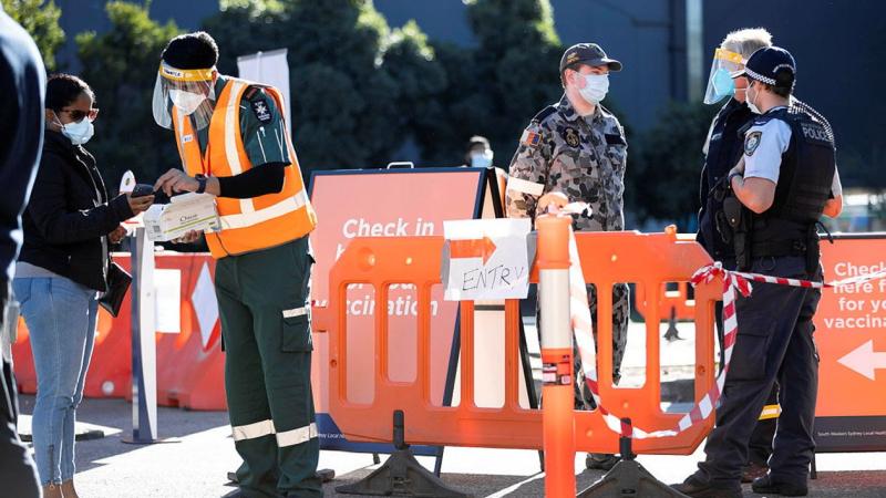 Seaman Nicholas Hopkins talks with members of the NSW Police and NSW Rural Fire Service at the Prariewood Community Centre Vaccination Hub in Fairfield, Sydney. Photo: Corporal Dustin Anderson