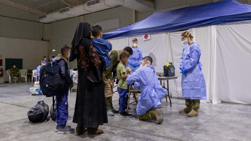 An Australian Defence Force medic assesses a child in the evacuee handling centre at Australia’s main operating base in the Middle East. Photo: Leading Aircraftwoman Jacqueline Forrester