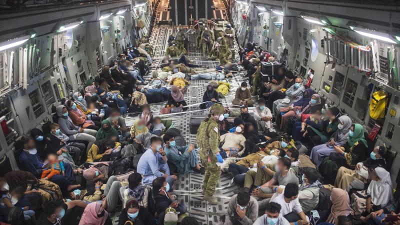 Australian citizens and visa holders evacuated from Afghanistan on board a RAAF C-17A Globemaster III, enroute to the ADF’s main operating base in the Middle East region. Photo: Sergeant Glen McCarthy