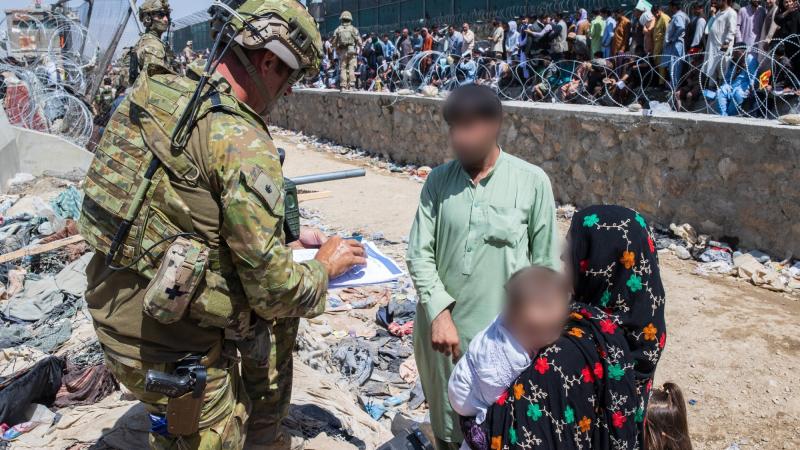 Major Tim Glover assists DFAT members locate Afghan Australian visa holders attempting to enter the congested Abbey Gate at Hamid Karzai International Airport. Photo: Sergeant Glen McCarthy