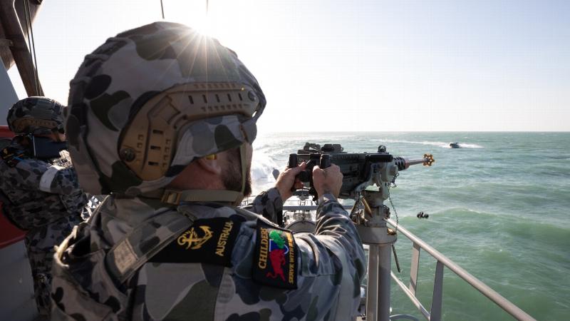 Leading Seaman Boatswains Mate Thomas Kelly engages a ‘hostile’ craft with a 12.7mm heavy machine gun aboard HMAS Childers during a defensive training activity. Photo: Petty Officer Peter Thompson