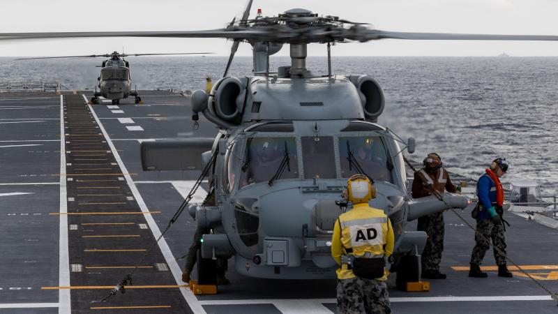 Royal Malaysian Navy Super Lynx and RAN MH-60R helicopters perform deck landing exercises on board HMAS Canberra as part of the Malaysia-Australia Training Exercise. Photo: Petty Officer Christopher Szumlanski