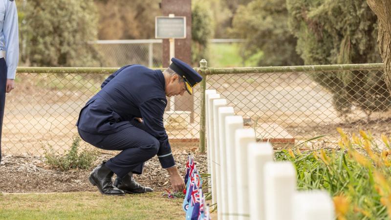Air Commodore Ross Bender lays a sprig of rosemary at one of the grave sites during a commemoration ceremony at Mallala War Cemetery. Photo: Leading Aircraftman Stewart Gould