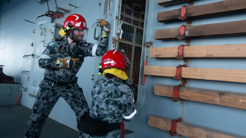 Able Seaman Paul Murra and Able Seaman Lydia Monk participate in a fire hose drill during damage control training on board HMAS Sirius.