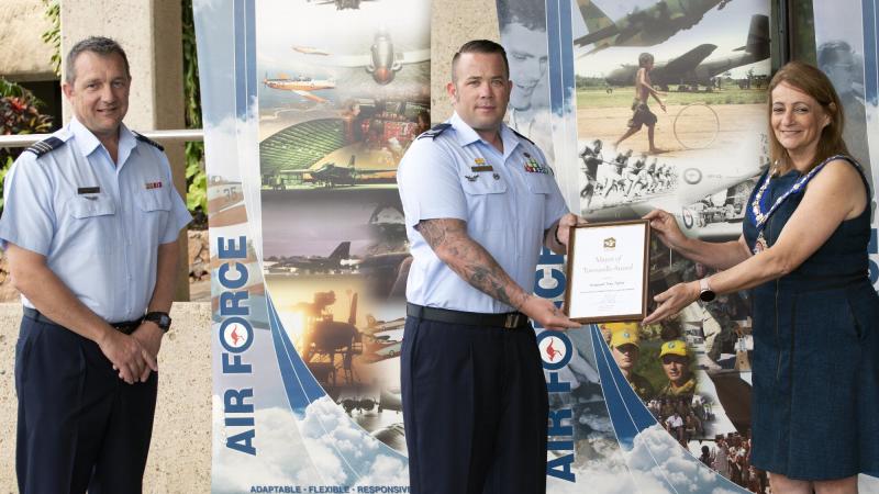 Senior ADF officer at RAAF Base Townsville Wing Commander Mathew Green watches on as Sergeant Tory Tipler is presented with his award by Townsville Mayor Jenny Hill.