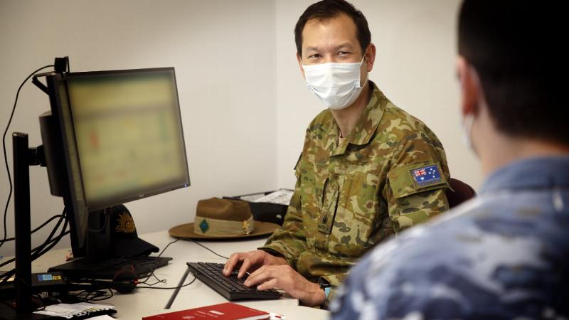 Major Timothy Chan, Officer Commanding Bravo Company, Joint Task Force 629.1.1, works with a member of the task force at HMAS Kuttabul, Sydney. This image has been digitally altered. Photo: Aircraftwoman Kate Czerny