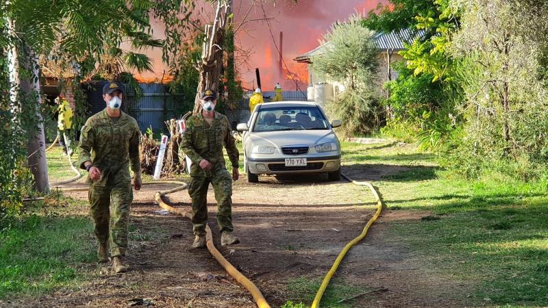Australian Defence Force members assist firefighters and police during a fire in Bourke.