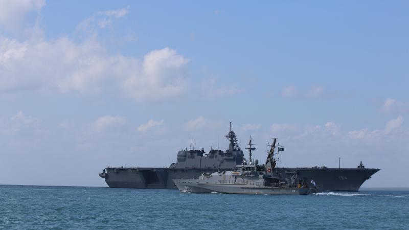 HMAS Maitland sails past Japan Maritime Self-Defense Force Ship Kaga as they part ways in the waters off Darwin.
