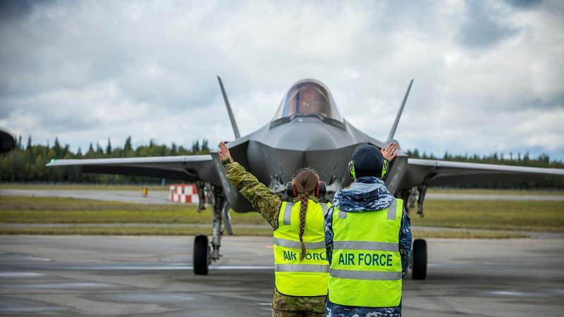 Leading Aircraftman Paul Taylor supervises Aircraftwoman Milena Frolova from No. 3 Security Forces while marshalling an F-35A Lightning II from No. 3 Squadron at Eielson Air Force Base in Alaska, United States. Photo: Flying Officer Bronwyn Marchant