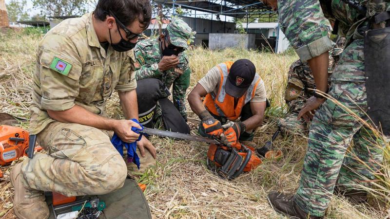  Corporal Zed Zapletal works alongside Timor-Leste Defence Force soldiers during a lesson on chainsaw maintenance and operation during Exercise Hari'i Hamutuk 2021 at Metinaro Military Base, Timor-Leste. Photo: Leading Seaman Jarrod Mulvihill