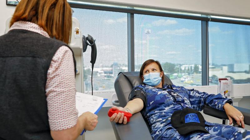 Enrolled nurse Nicole Gentry prepares Flight Sergeant Kate Morris, of No. 295 Squadron, for her plasma donation at the Red Cross Ipswich Donation Centre in Queensland. Photo: Corporal Nicci Freeman