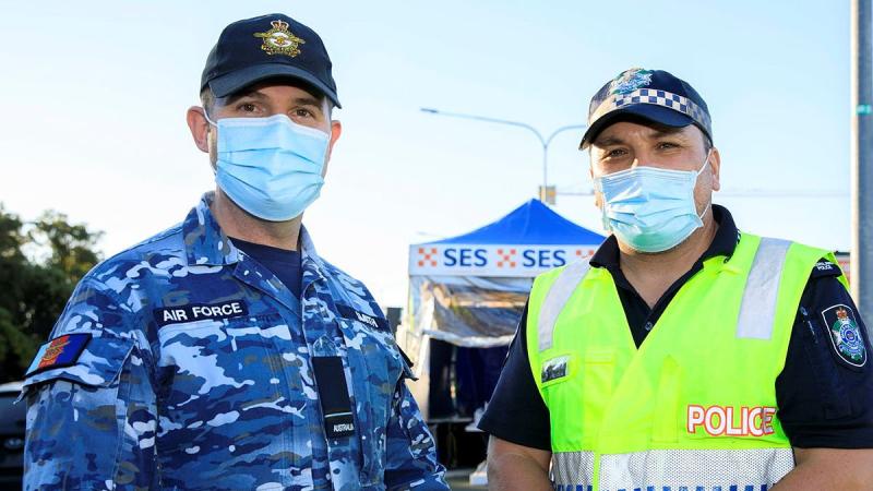 Flying Officer Brett Smith talks with his mate and former colleague Senior Constable Jared Cowan at the Gold Coast Highway police checkpoint. Photo: Corporal Brett Sherriff