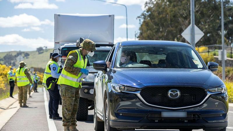 Lance Corporal Mancell Laidler, of Joint Task Group 629.9, inspects the licence of a motorist at the ACT Federal Highway border-control point during Operation COVID-19 Assist. Photo: Corporal Jarrod McAneney