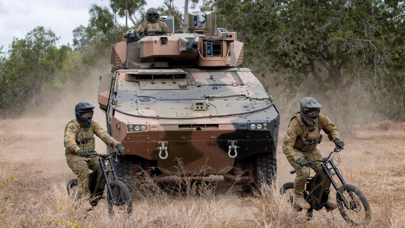 Trooper Damian Day, left, and Corporal Thomas Ovey from the 2nd/14th Light Horse Regiment (Queensland Mounted Infantry) conduct a scouting patrol on stealth reconnaissance e-bokes at the Townsville Field Training Area. Photo: Corporal Nicole Dorrett