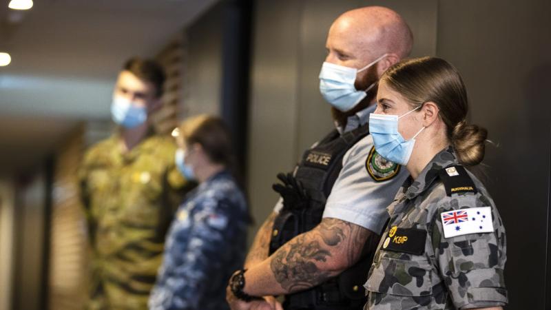 NSW Police Senior Constable Peter Heginbotham, front left, and Midshipman Bridie Kemp on hotel quarantine duties during Operation COVID-19 Assist. Photo: Corporal Dustin Anderson
