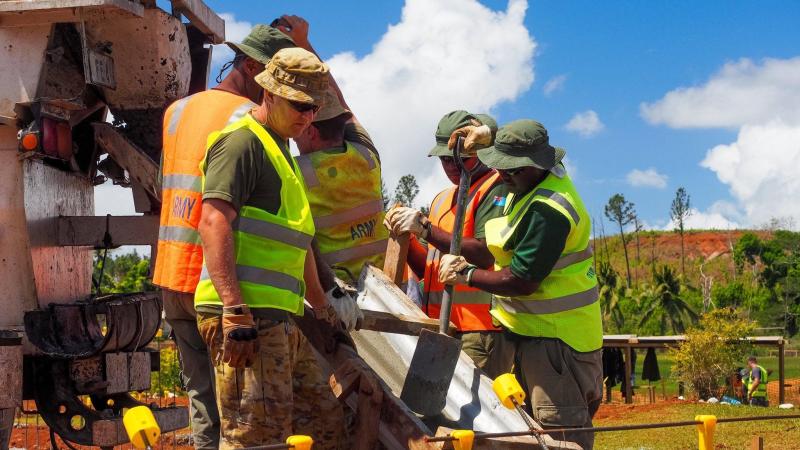 Captain Thomas Sefton, front, and other members of the ADF construction engineer team place concrete into the footings of a new classroom building at Lekutu Secondary School in Fiji.