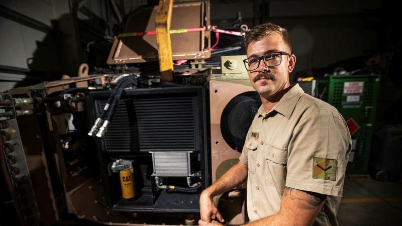 Lance Corporal Timothy Pates in front of a protected mobility vehicle, which has been prepared for deep clean at Australia's main operating base in the Middle East. Photo: Sergeant Glen McCarthy