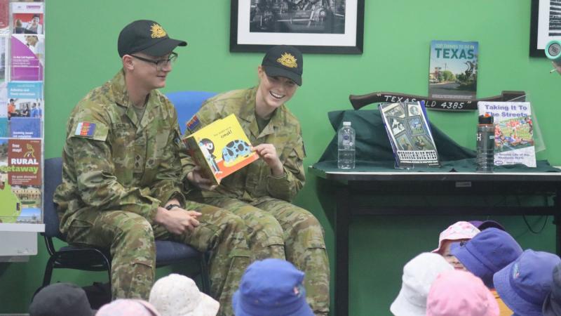 Lieutenant Thomas McAllister and Private Nikita Booth read a story to some children at the library in Texas, Queensland.