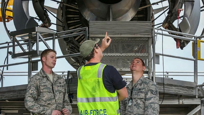 RAAF and US aviators discuss the maintenance of an aircraft.