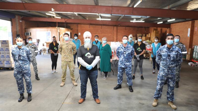 Turbans 4 Australia President Amar Singh with ADF members at the charity's warehouse in Clyde, NSW.