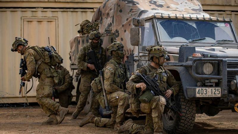 Soldiers from the 6th Battalion, Royal Australian Regiment, take cover behind a G Wagon during urban operations training at Townsville. Photo: Corporal Nicole Dorrett