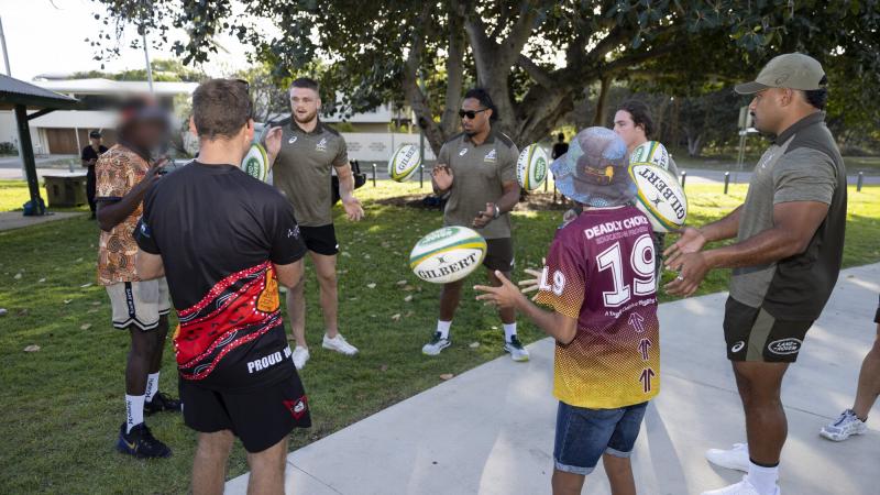 Wallabies rugby union players pass footballs with participants of the Proud Warrior Youth Engagement Program at Pallarenda Beach, Queensland. Photo: Corporal Brandon Grey