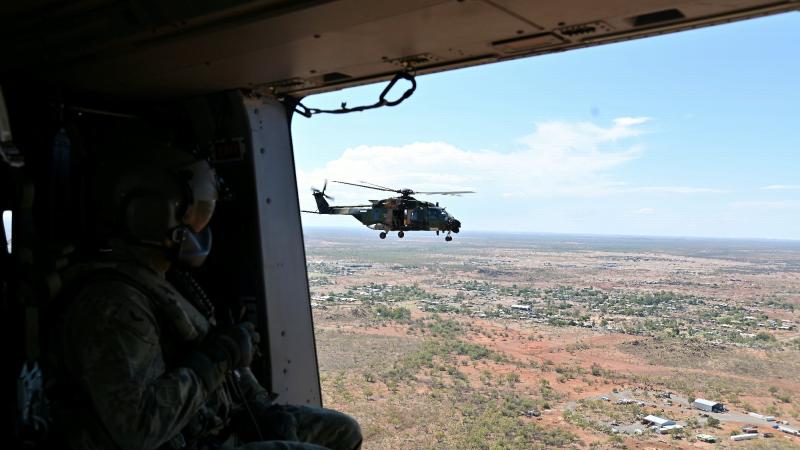 An Australian Army aircrewman from the 5th Aviation Regiment surveys the town of Cloncurry, from an MRH-90 Taipan helicopter. Photo: Captain Carolyn Barnett