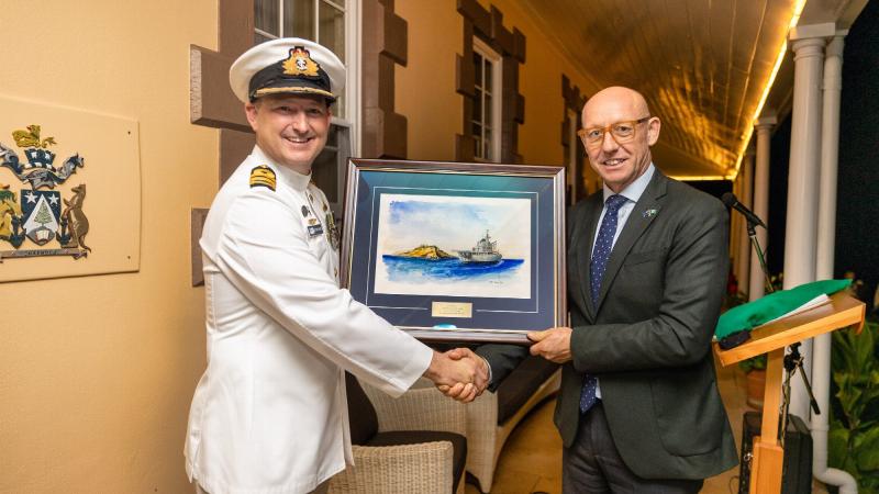 Commander Christopher Doherty presents the painting to the Administrator of Norfolk Island, Eric Hutchinson. Photo: LSIS Sittichai Sakonpoonpol