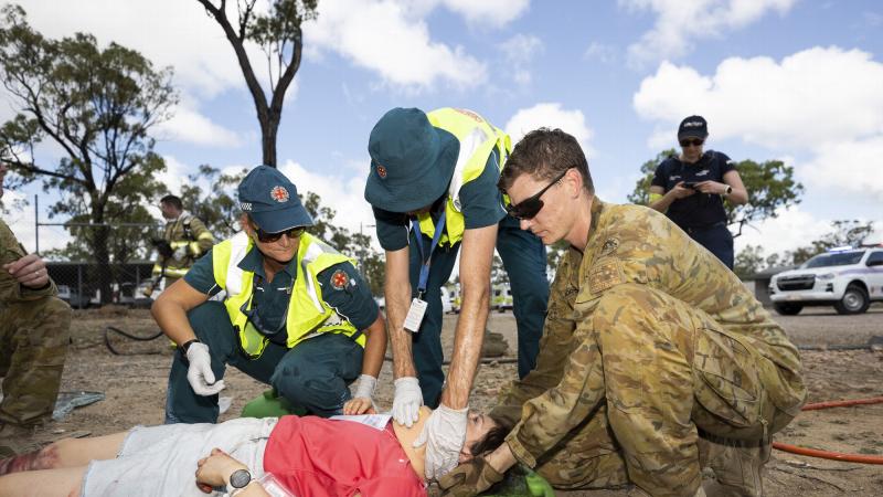 A soldier from the 3rd Combat Engineer Regiment helps Queensland Ambulance Service paramedics during a mass casualty scenario at Townsville field training area. Photo: Corporal Brandon Grey