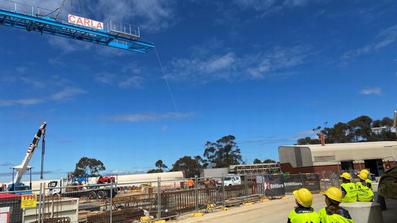 Students from Puckapunyal Primary School watch on as 'Carla the Crane' is erected at the Stage 1 – Armoured Fighting Vehicle Facilities Program project site at the School of Armour.