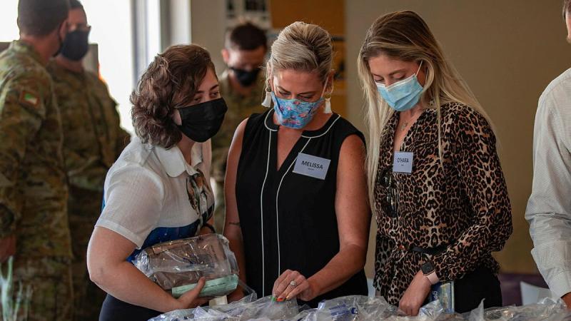 Department of Veterans' Affairs staff Caitlin Frost, left, Melissa Morrison and O’Hara Nailon sample a 24-hour ration pack during a visit to Gallipoli Barracks, Brisbane. Photo: Corporal Nicole Dorrett