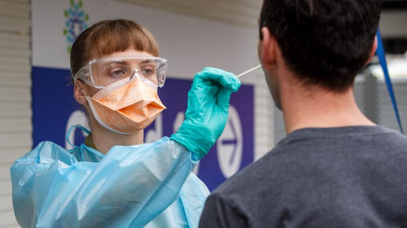 Lieutenant Mia Parsons, of the 1st Close Health Battalion, takes a COVID test sample from a member of the public at the Goulburn Valley Health COVID testing site in Shepparton, Victoria. Photo: Private Dustin Anderson
