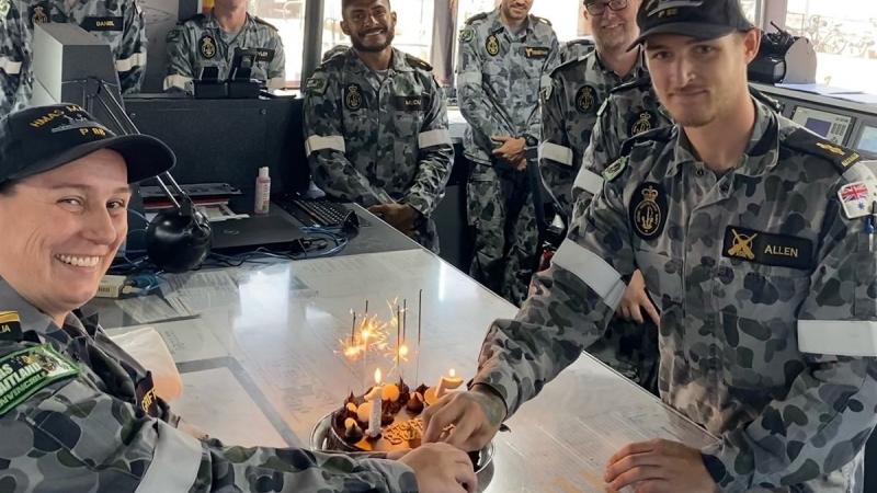 Commanding Officer HMAS Maitland Lieutenant Commander Julia Griffin and Able Seaman Samuel Allen prepare to cut a cake celebrating the Armidale-class patrol boat's 15th birthday.