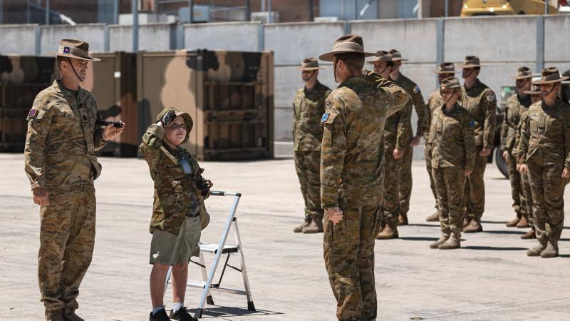 Make-A-Wish recipient Adam salutes the Commanding Officer of the 2nd Combat Engineer Regiment, Lieutenant Colonel Henry Stimson, while on parade during his visit to Gallipoli Barracks, Brisbane. Photo: Corporal Nicole Dorrett