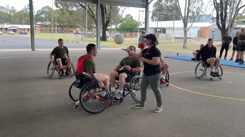 Veteran engagement specialist from Invictus Australia, Rachael Kerrigan, umpires a wheelchair basketball game with soldiers from the School of Infantry at an adaptive sport demonstration event at Singleton, NSW.