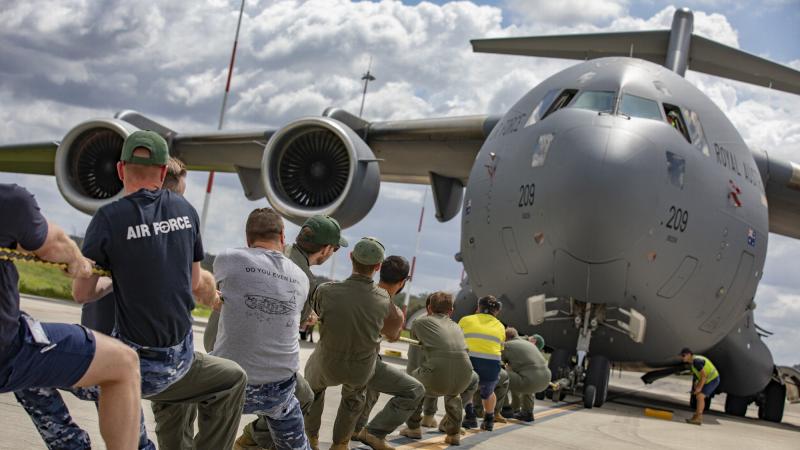 No. 36 Squadron aviators pull a C-17A Globemaster III aircraft during the tug-o-war challenge at RAAF Base Amberley. Photo: Corporal Jesse Kane