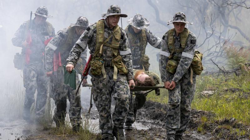 (Left) Royal Australian Naval College New Entry Officers' Course 65 Midshipman Stuart Munro and Midshipman Ellen Kozlowska carry the front of a stretcher after rescuing an unconscious pilot during a training scenario for Exercise Matapan at HMAS Creswell,