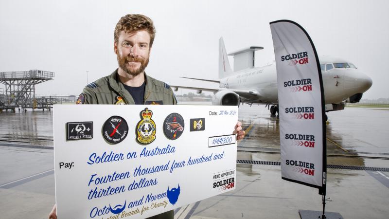 Flight Lieutenant Brendan Campbell with a cheque for funds raised for Soldier On. Photo: Corporal Craig Barrett