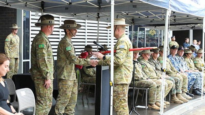 Outgoing Commander 1st Division Major General Jake Ellwood, centre, accepts the 1st Division pennant from Regimental Sergeant Major Warrant Officer Class One Michael Landy during the command handover parade. Photo: Sergeant Kerry Uilderks