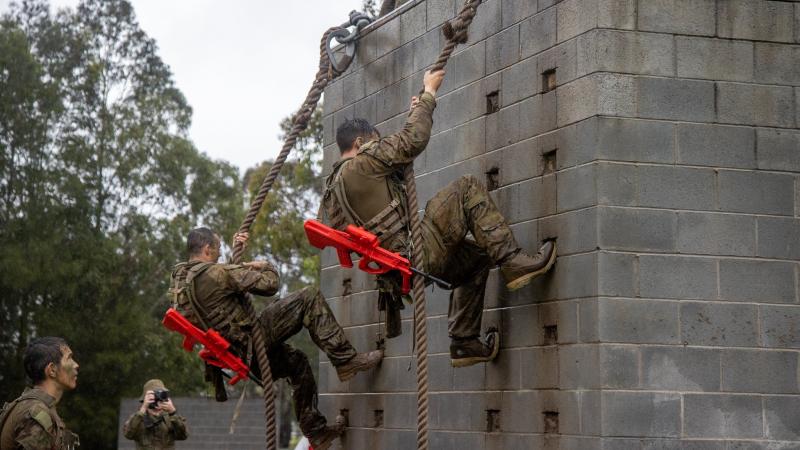 Privates Meaham Bailey, left, and Bagu Tancredi climb the rope wall as part of Exercise Hardcorps at the School of Infantry, Singleton, New South Wales. Photo: Corporal Shane Kelly