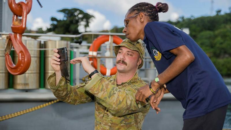 Captain Taylor Lynch, from the ADF Mobile Training Team, discusses photography techniques with Vanuatu Police Force Media team leader Sackrine Kaman during the Public Affairs Course in Port Vila, Vanuatu. Photo: Corporal Robert Whitmore