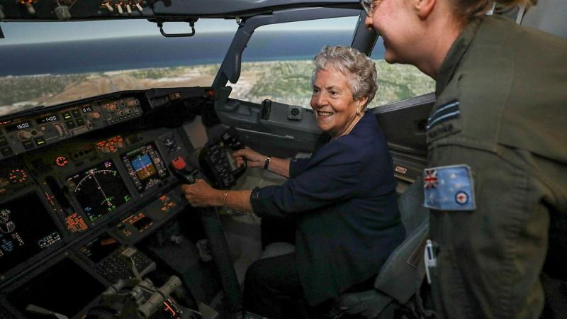 Former Women's Royal Australian Air Force member Valarie Rappold is shown how to fly the P-8 Poseidon simulator by No. 11 Squadron pilot Flight Lieutenant Larissa Stephens at RAAF Base Edinburgh. Photo: Corporal Brenton Kwaterski