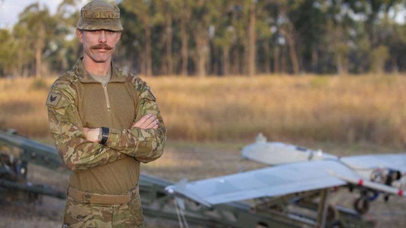 Sergeant Marc Plant stands in front of a Shadow 200 UAS. Photo: Petty Officer Lee-Anne Cooper
