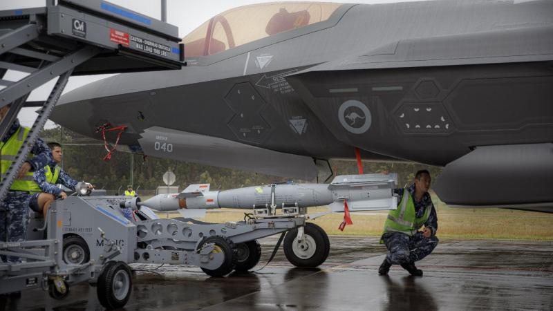 Armament Technicians from No. 3 Squadron, load a new Australian manufactured Bomb Live Unit (BLU 111) configured as a Guided Bomb Unit (GBU-12) onto F-35A Lightning II aircraft A35-040 at RAAF Base Williamtown, NSW. Photo: Corporal Craig Barrett
