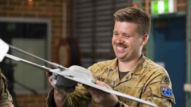 Bombadier Mitchell Yates looks at a Wasp AE Small UAS at the Army Reserve Kogarah Depot in Sydney. Photo: Corporal Dustin Anderson